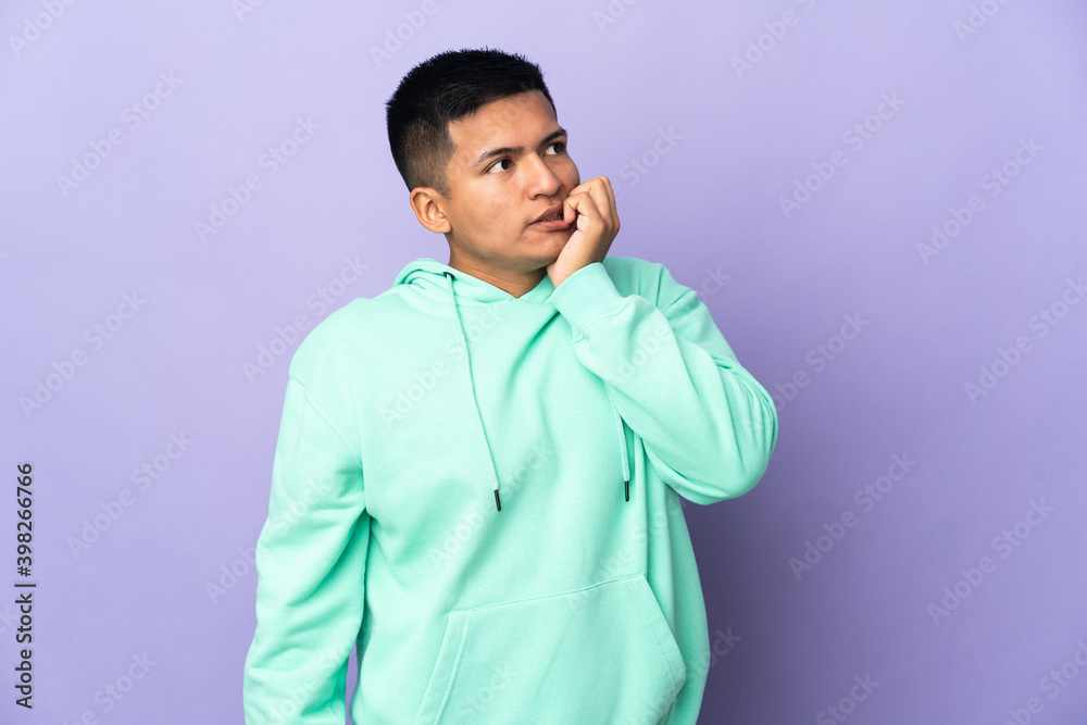 Young Ecuadorian man isolated on purple background is a little bit nervous Young Ecuadorian man isolated on purple background is a little bit nervous