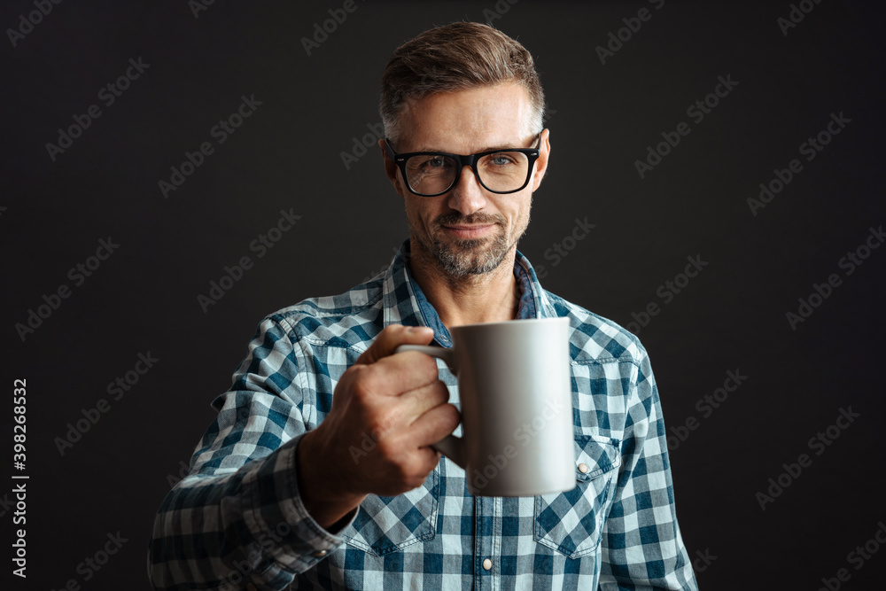 Man holding cup of coffee isolated over grey wall background