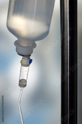 Closeup of a saline IV drip Infusion bottle with IV solution for patients in hospital, selective focus with blurred background