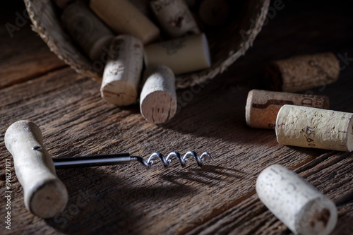Wine corks with corkscrew on wooden background. 