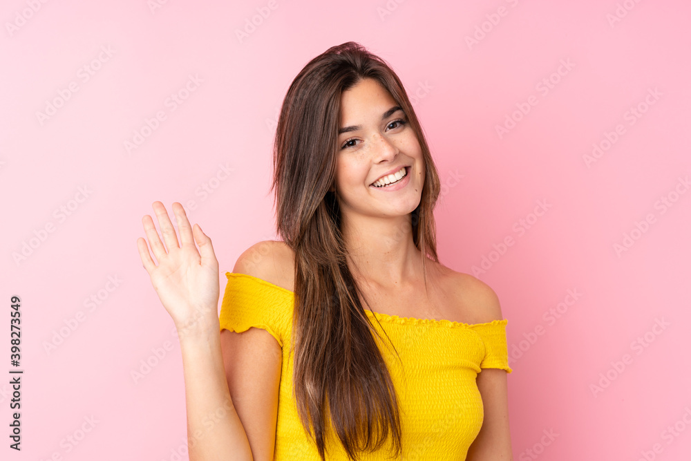Teenager Brazilian girl over isolated pink background saluting with hand with happy expression Teenager Brazilian girl over isolated pink background saluting with hand with happy expression