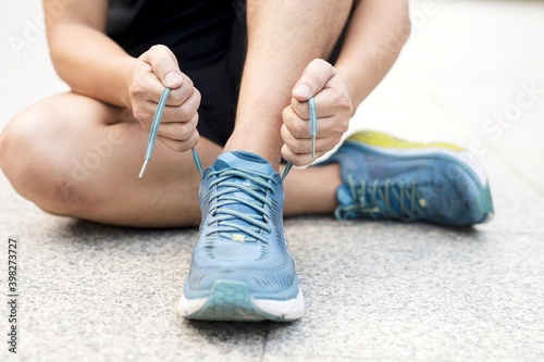 man hands tying shoelaces before running.
