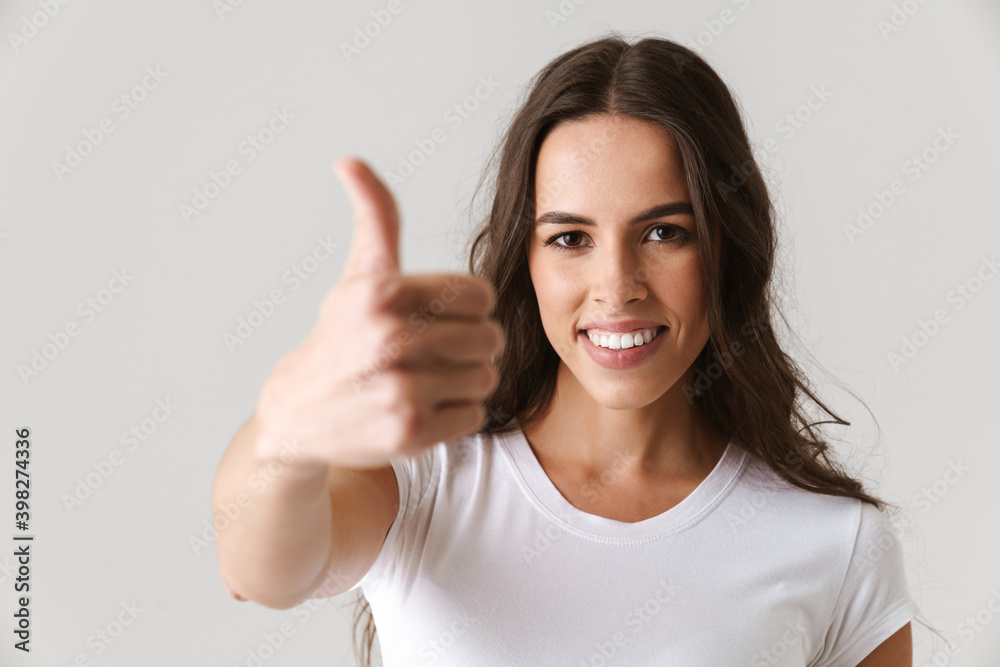 Happy beautiful girl smiling and showing thumb up at camera Happy beautiful girl smiling and showing thumb up at camera