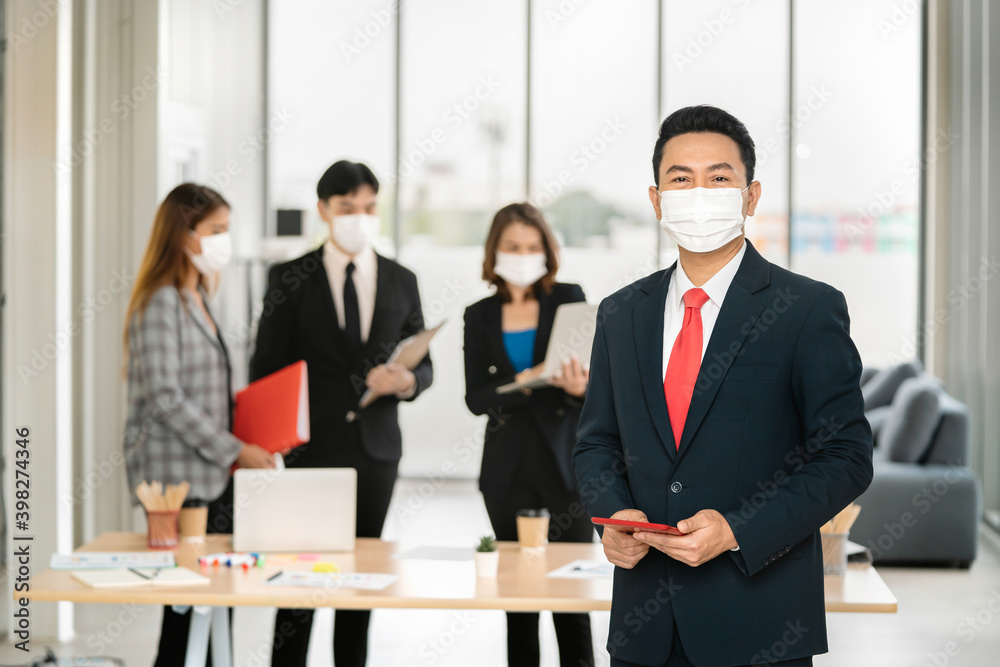 businessman standing with holding mobile in office