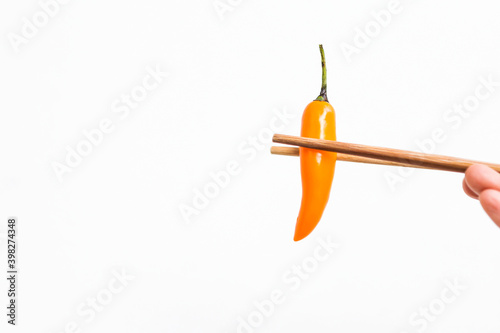 Yellow chilli with chopsticks isolate on white background, spicy food, fresh chilli