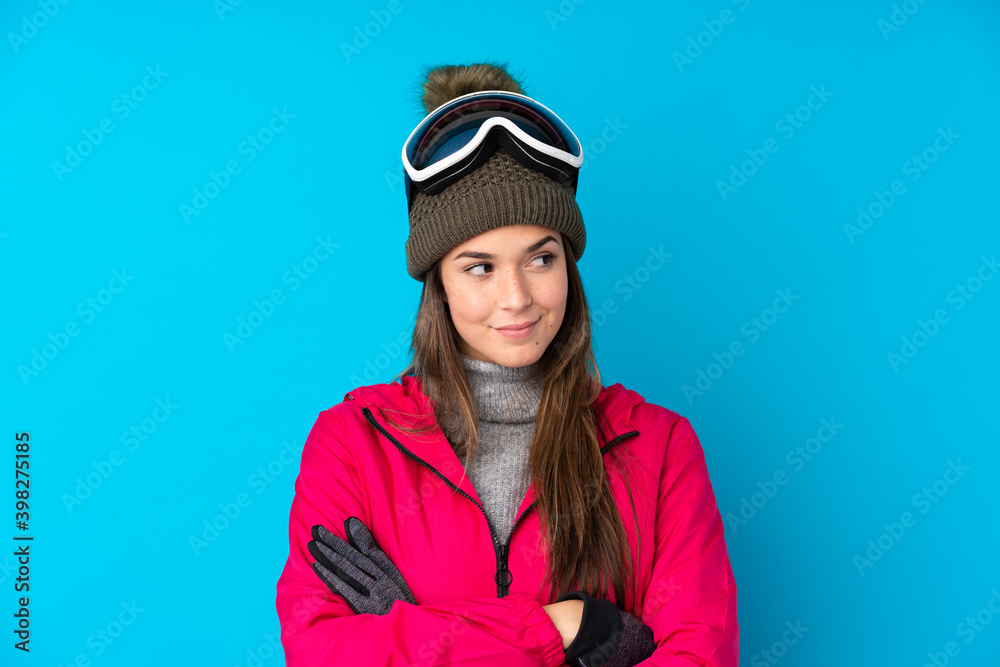 Teenager skier girl with snowboarding glasses over isolated blue background thinking an idea Teenager skier girl with snowboarding glasses over isolated blue background thinking an idea