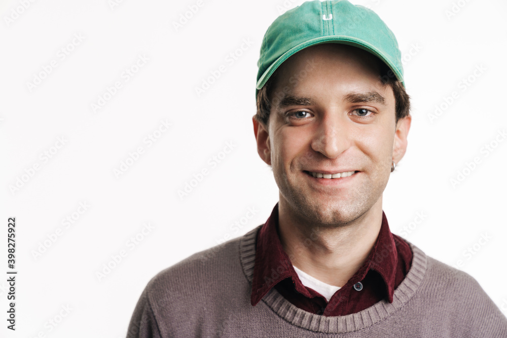 Young happy man in cap smiling and looking at camera Young happy man in cap smiling and looking at camera