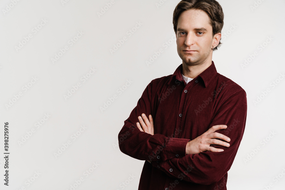 Handsome serious young man posing with arms crossed Handsome serious young man posing with arms crossed