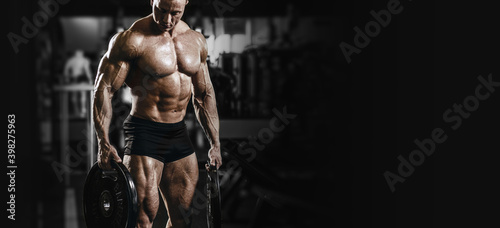 Muscular athletic bodybuilder fitness model doing exercises in gym. © Fotokvadrat