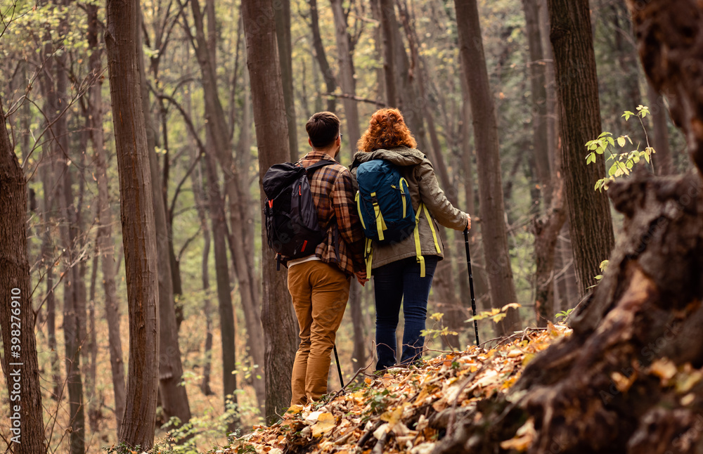 Rear view of two young hikers with backpack walking in forest. Rear view of two young hikers with backpack walking in forest.