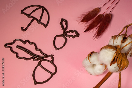 3D printed acorns, leaves and umbrella on a pink background with chocolate