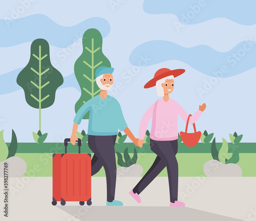 active seniors couple traveling with suitcases