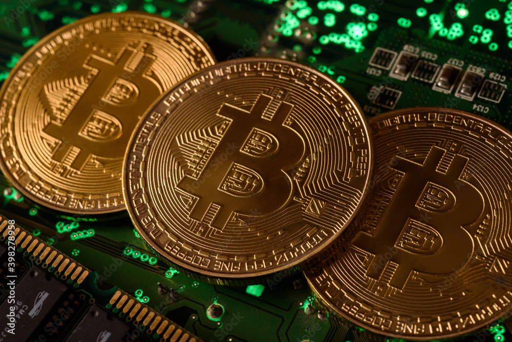 In this photo illustration, Bitcoin cryptocurrency commemorative coins on circuit board.