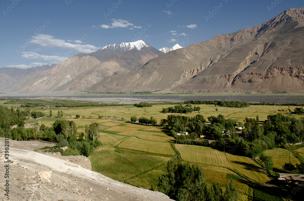 Scenic view of a large river and a cultured valley under mountains