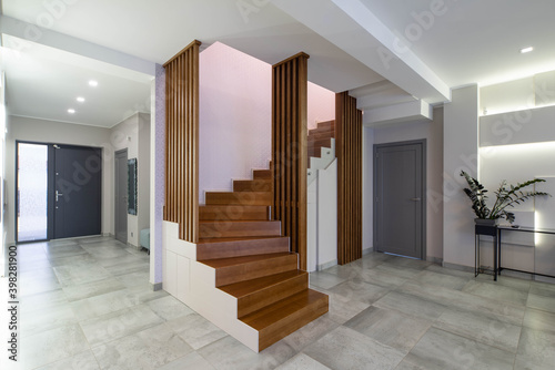 Contemporary interior of luxury flat. Hi-tech design of wall with lamps. Wooden staircase. Home decor. © Aleks Kend