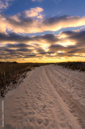 Sandy beach road leading to a vibrant golden sunset. Jones Beach New York