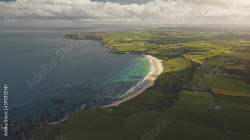 Wallpaper Mural Green farmland at sun ocean bay aerial. Nobody nature landscape. Yellow fields, greenery meadows at summer day. Calm ocean seascape. Rural meadows and lands. Northern Ireland, United Kingdom, Europe Torontodigital.ca