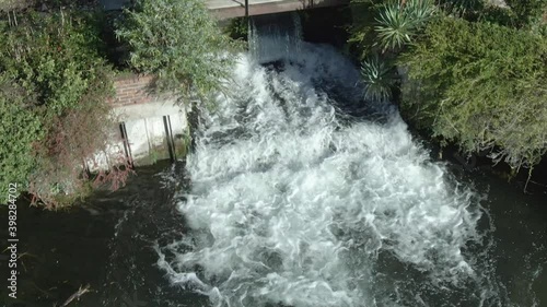 Aerial of water flowing quickly through weir in the River Lambourn photo