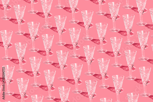 A pattern of champagne glasses on a pink background. Christmas seamless pattern