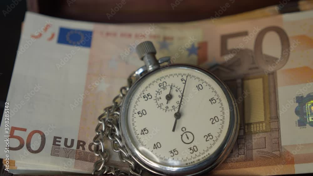 Close-up Of Stopwatch In Front Of Euro Banknotes Close-up Of Stopwatch In Front Of Euro Banknotes