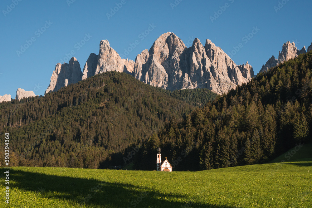 Beautiful view of the Puez Odle National Park and the church in a sunny day of summer, Dolomites, Italy