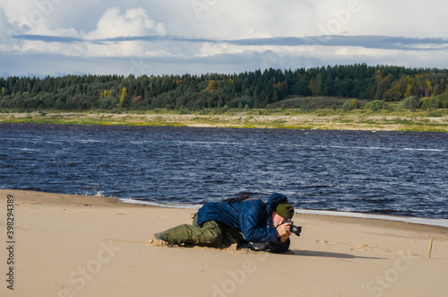 The photographer lies on the sand. Macro photography. Passion
 photo