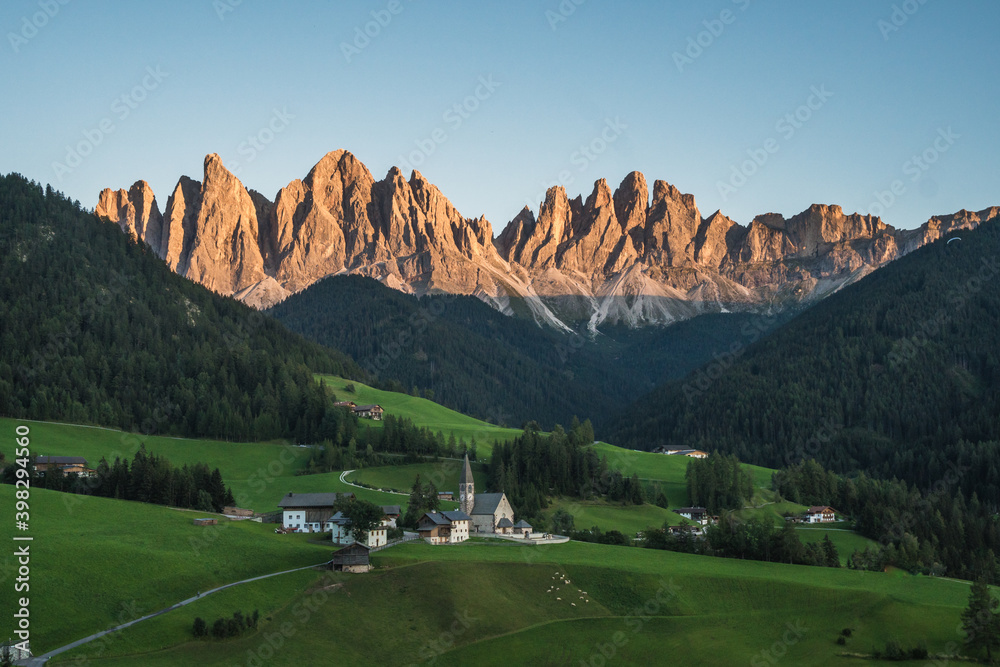 Beautiful view of the Puez Odle National Park and the Santa Magdalena Church at sunset, Dolomites, Italy