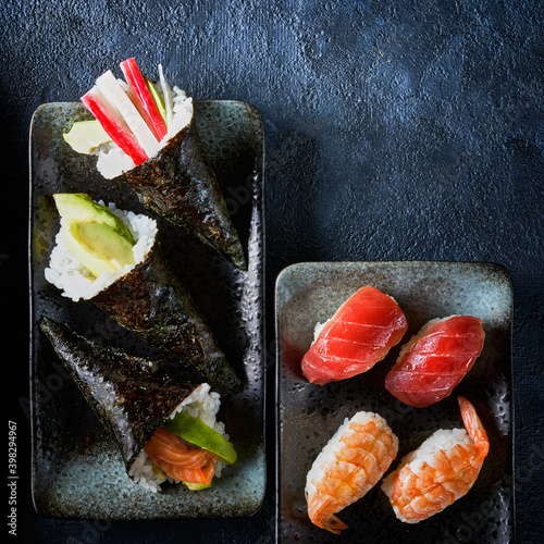 Set of maki and nigiri sushi with salmon, tuna, shrimp, avocado, crab sticks prawns, on dark background Copy space. Top view. Traditional Japanese cuisine. photo