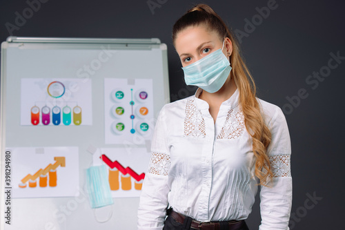Tired businesswoman wearing a medical mask at a presentation. Pandemic, business concept. photo