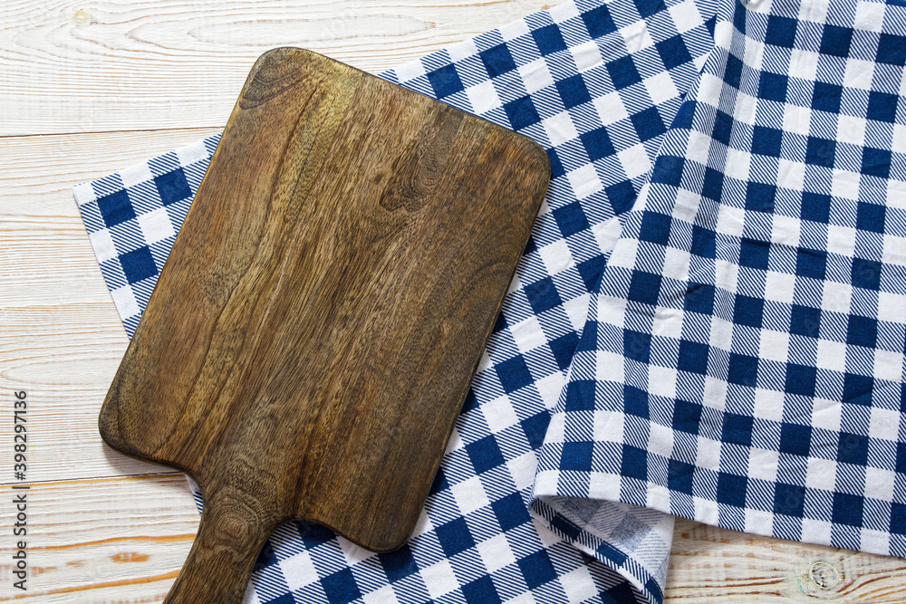 Close up of cutting board with chekered tablecloth on wooden background. Close up of cutting board with chekered tablecloth on wooden background.