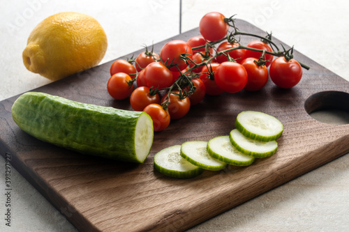 Sliced cucumber and cherry tomatoes on a butcher block