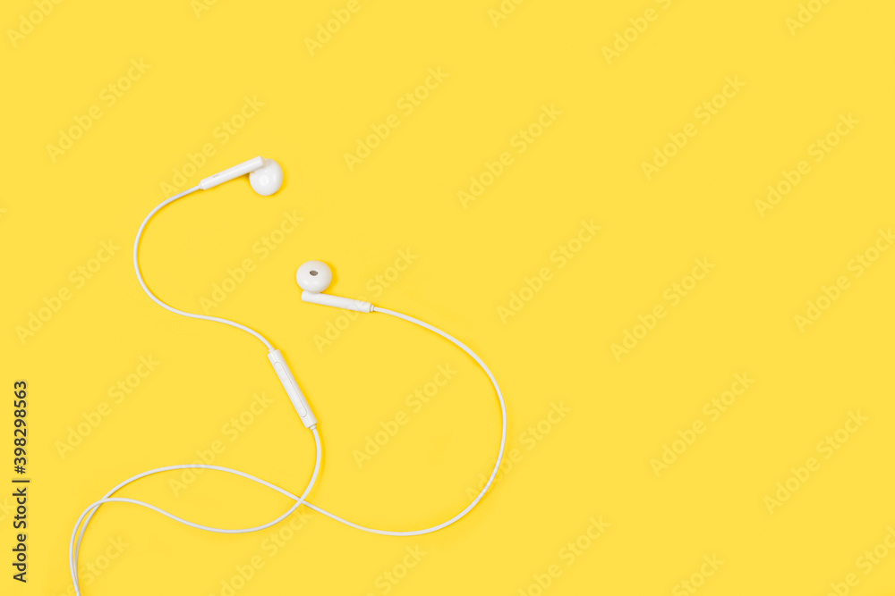 Auriculares blancos sobre un fondos amarillo liso y aislado. Vista superior. Copy space. Estilo minimalista Auriculares blancos sobre un fondos amarillo liso y aislado. Vista superior. Copy space. Estilo minimalista