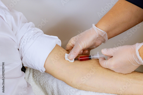 Laboratory nurse takes blood sample from arm on the analysis