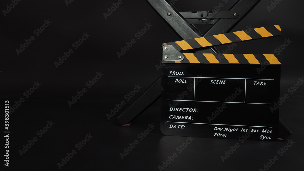 Director chair and Clapper board or Clapperboard or movie slate use in video production or film and cinema industry. It's put on black blackground.
