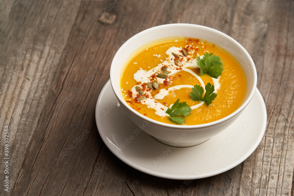 Pumpkin soup on a wooden table. Pumpkin soup puree Pumpkin soup on a wooden table. Pumpkin soup puree