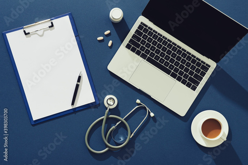 Doctors desktop with stethoscope and medical supplies photo