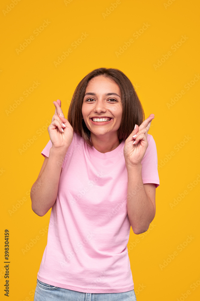 Excited woman making wish with crossed fingers Excited woman making wish with crossed fingers