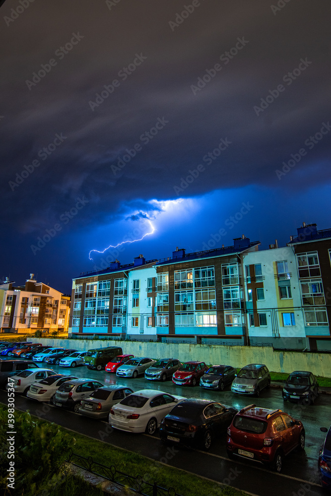 lightning bolt in stormy sky above the night city