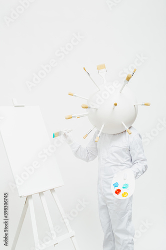 Artistic character with a big round head full of brushes working in his work. photo