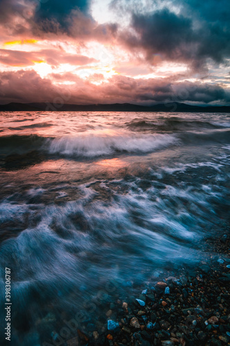 Waves of the lake at stormy sunset long exposure