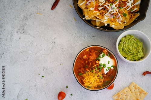 Skillet Turkey Chili Nachos topped with sourcream and guacamole