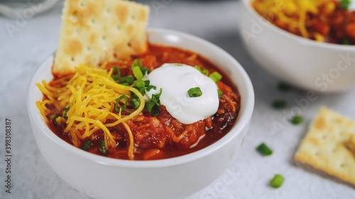 Homemade Turkey bean chili topped with sourcream cheese and green onions, selective focus