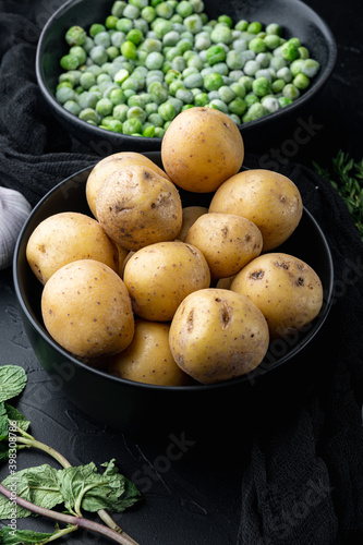 Pile of baby potatoes, on black textured background