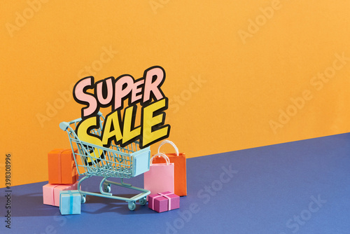 Shopping cart and paper bag with super sale text photo