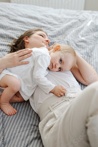 Mother lying on bed with baby
