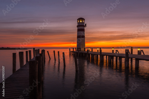 wooden jetties with lighthouse while sunset at the lake