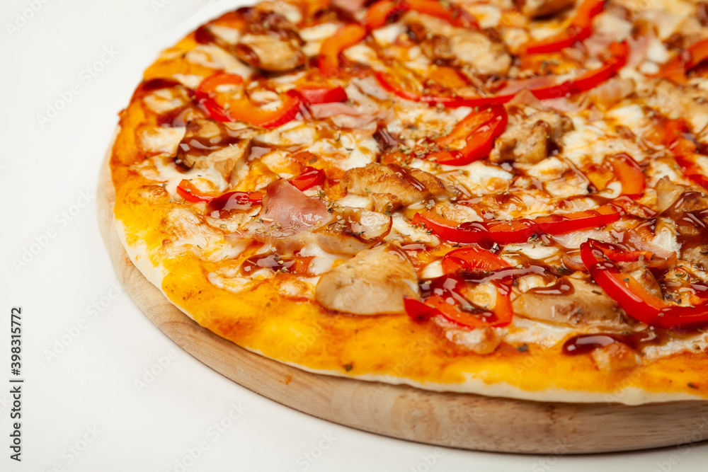 Delicious pizza with bacon and chicken Teriyaki served on a wooden plate, ingredients Signature sauce, mozzarella cheese, Teriyaki chicken, bacon, Bulgarian pepper, Teriyaki sauce on white
