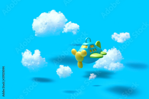 Flying airplain toy in a blue sky with cotton clouds. photo