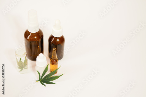 Fototapeta Naklejka Na Ścianę i Meble -  Glass bottles with cbd oil. Cannabis leaf. Medical marijuana threatment. White background. Copy space