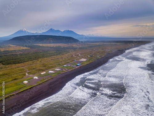 Ocean coastline with volcanic tops and camp on the beach, Kamchatka krai. photo